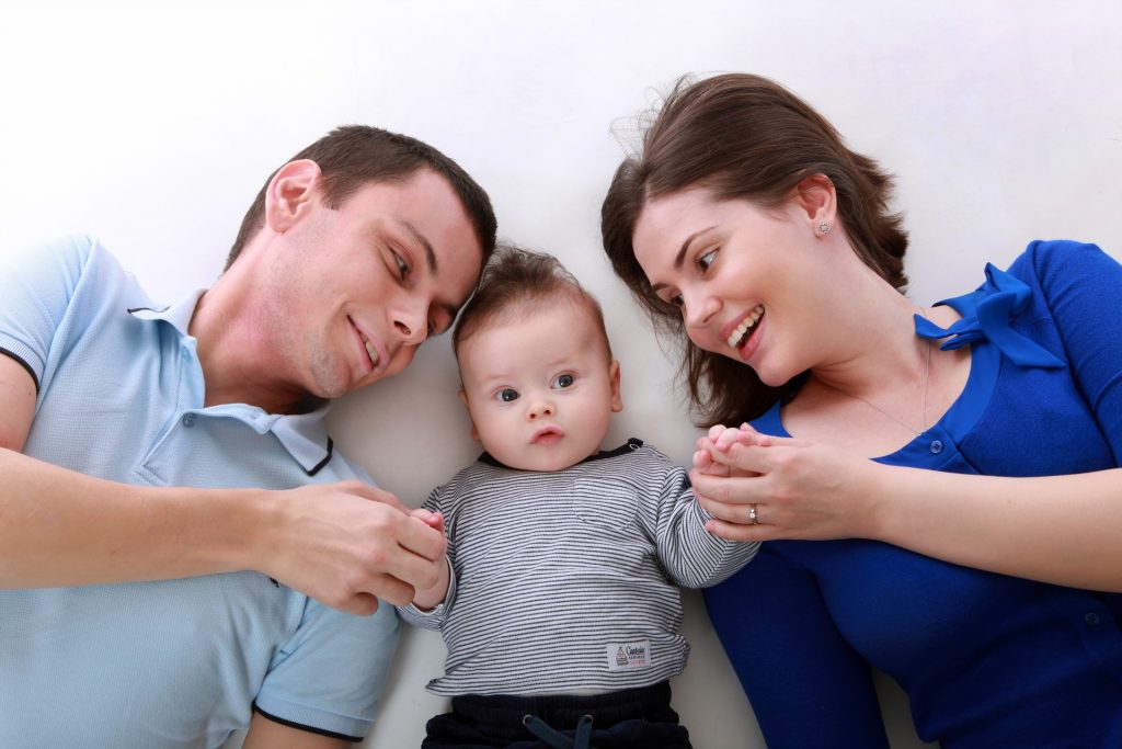 family together bed parents baby